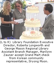Library Foundation Executive Director, Roberta Longworth and George Mason Regional Library Assistant Branch Manager, Marilynn Zauner accept Grand Mart check from Korean community representative, Ilryong Moon.