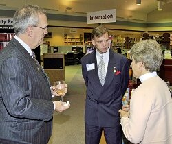 Library Director, Sam Clay and reception sponsor Doug Brammer of Verizon discuss library services with FCPL Trustee Mary Petersen.